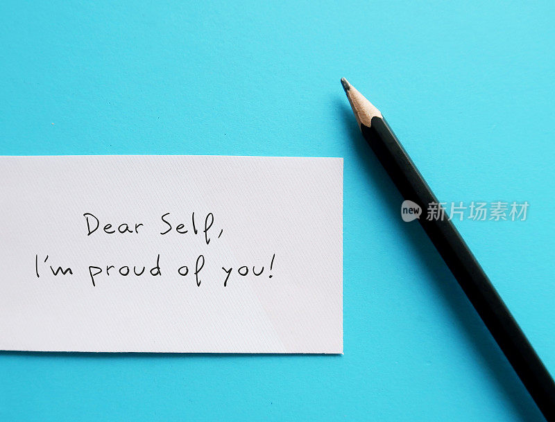 蓝底白纸，手写文字DEAR SELF, I'M PROUD OF YOU自爱肯定或自我意识，以增强自信